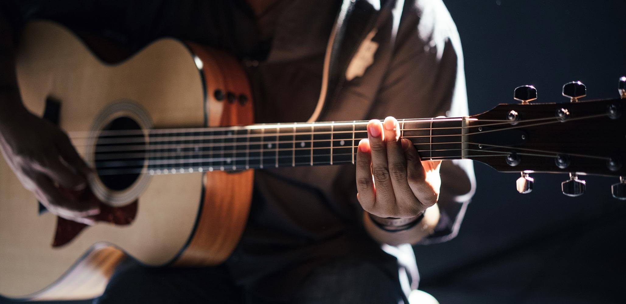 Closeup of someone playing the acoustic guitar