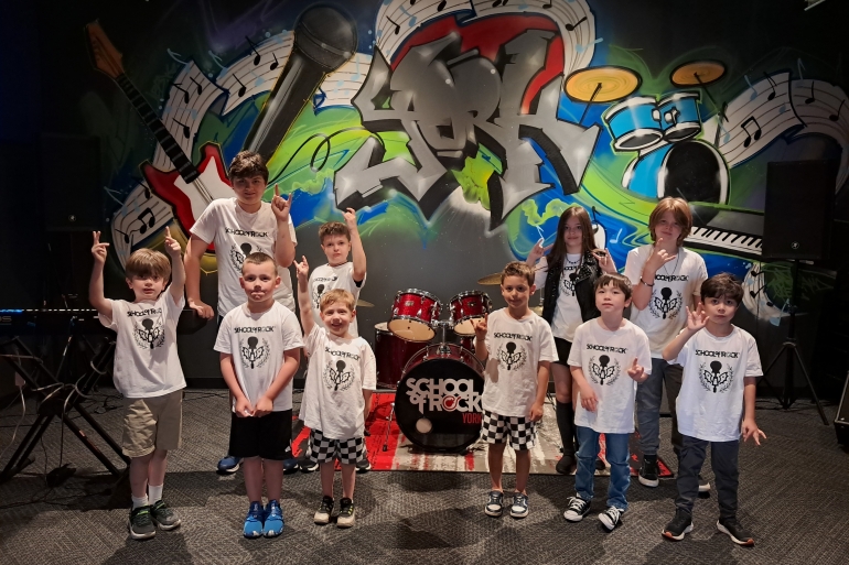 Students from School of Rock York 2025 Summer Camp season hold up 
