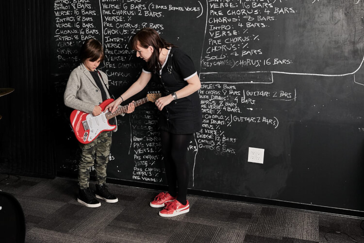 Instructor teaching guitar lessons for kids
