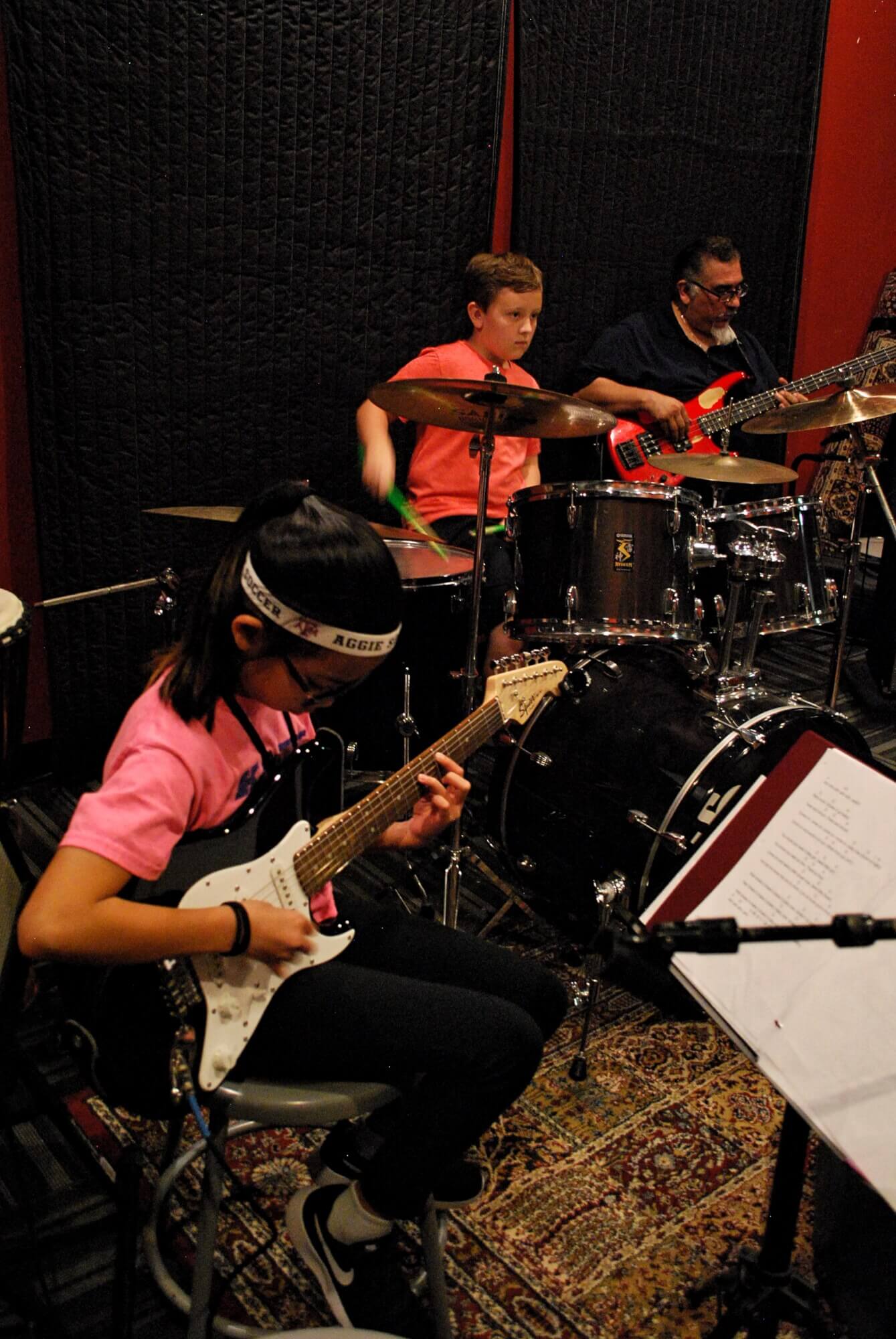 Rock 101 students work through their parts with Director Evetier Barron, laying down some bass.