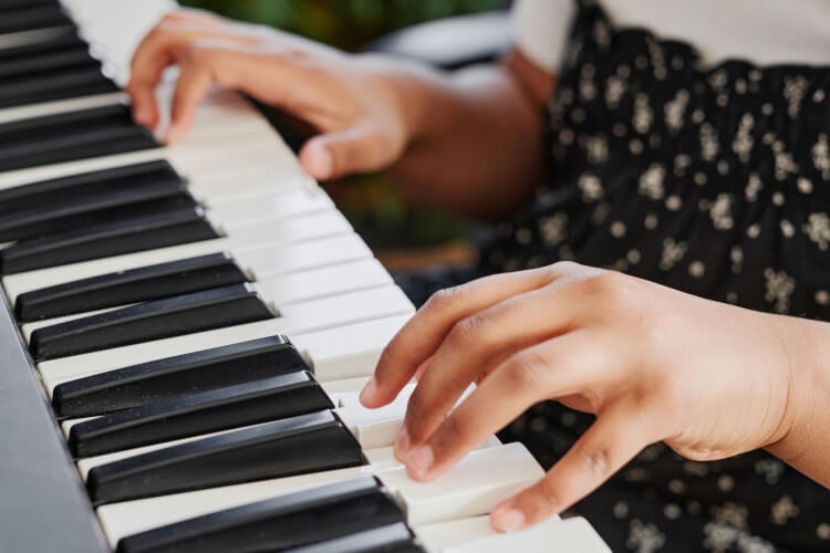 photo of young child playing keyboard
