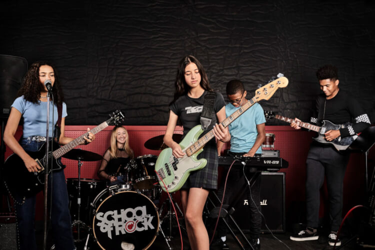 School of Rock students playing instruments in performance