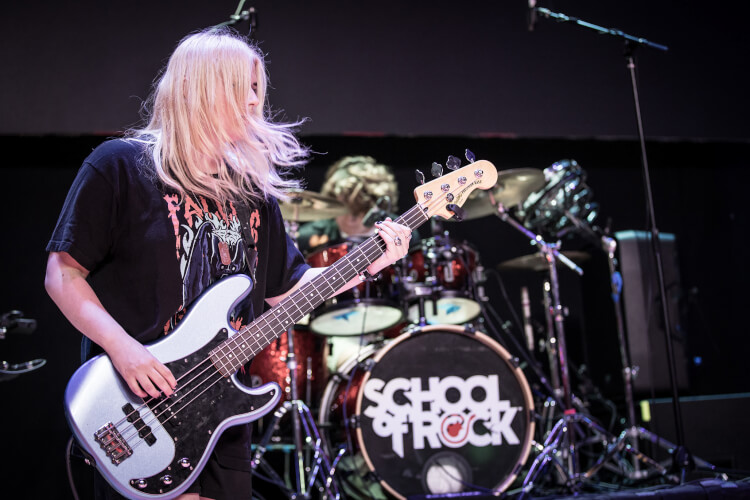 School of Rock student playing the bass guitar on stage