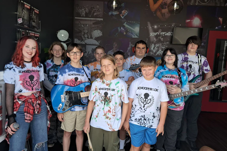 Students from the School of Rock York 2025 Summer Camp season pose with instruments