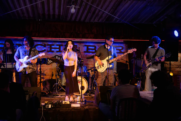 Ensamble de alumnos de Adult Performance Program de School of Rock Pedregal tocando en un escenario real de la CDMX.