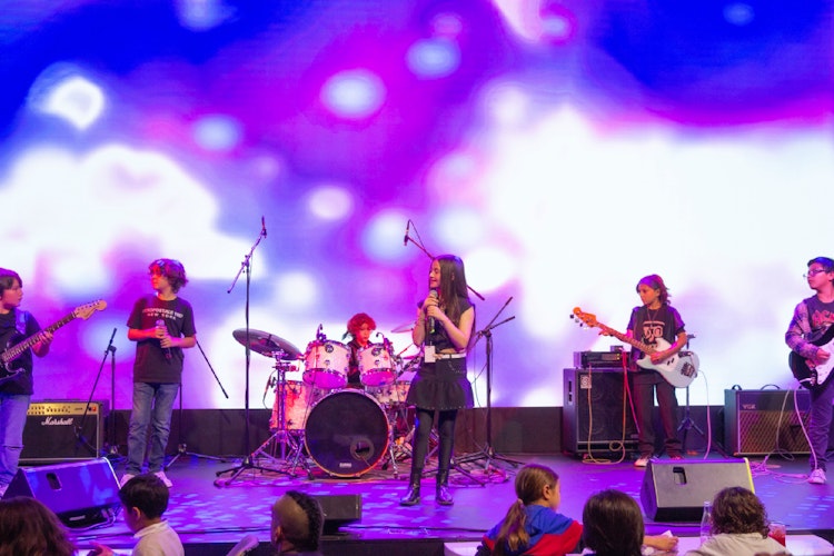 Un grupo de chicos del programa Rock 101, de 8 a 12 años, da un show de final de temporada en un escenario real de la CDMX.