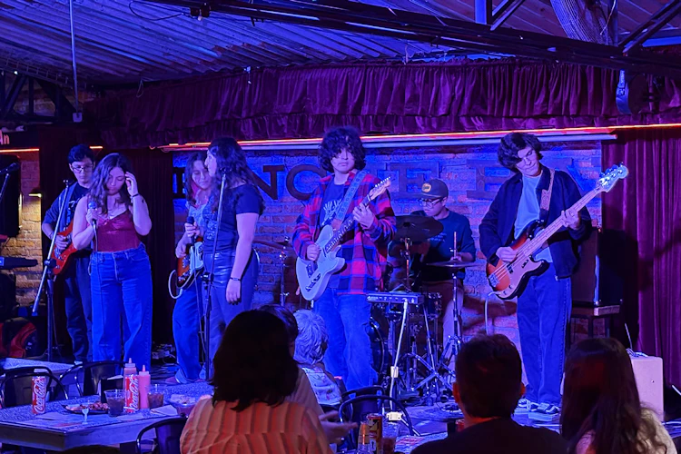 Grupo de alumnos adolescentes de Performance Program tocan en un escenario como parte de Rock a la Carta del Summer Club, clases de música al sur de la Ciudad de México.