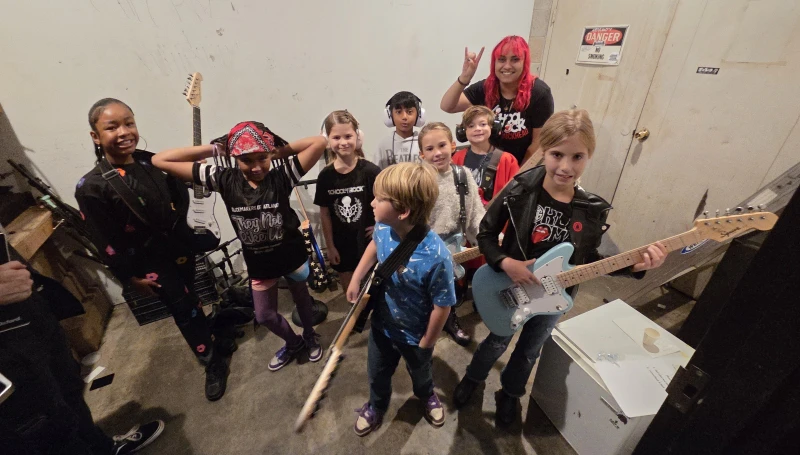 Young School of Rock Buckhead students making music together during a group rehearsal