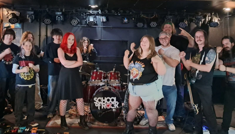 School of Rock York's House Band poses with their teachers on stage