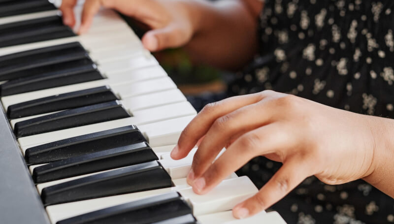 photo of young child playing keyboard