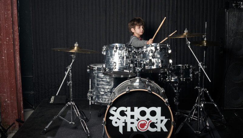 School of Rock student hitting a cymbal with a drum stick