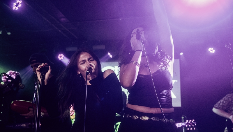 Two young musicians sing together, showcasing their vocal skills and the results of their music training at School of Rock.