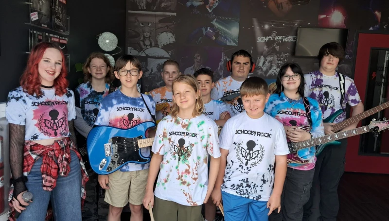 Students from the School of Rock York 2025 Summer Camp season pose with instruments