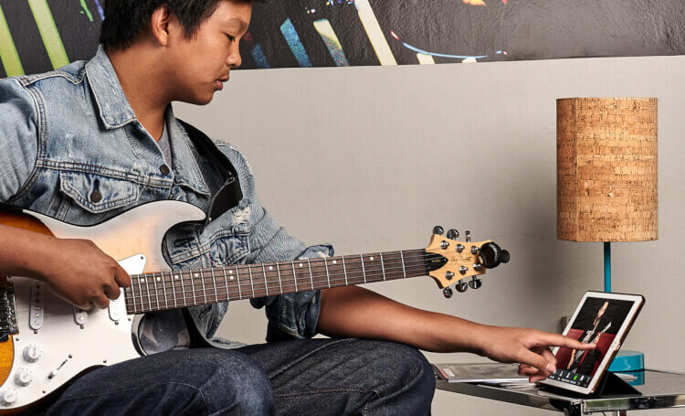 School of rock student learning to play guitar