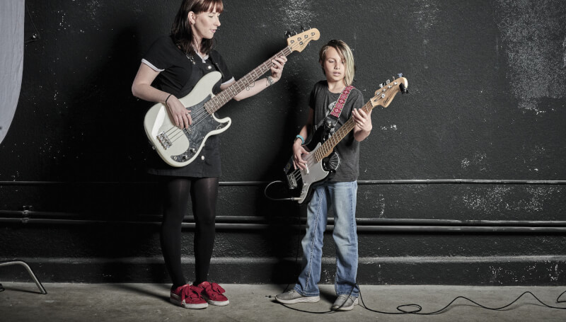 Teacher and student with bass guitars