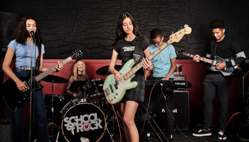 School of Rock students playing instruments in performance