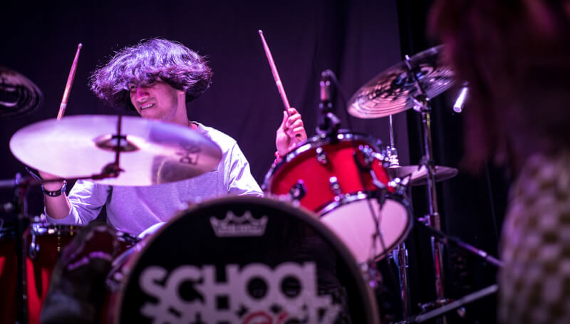 School of Rock student drumming on stage