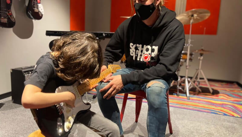 School of Rock student learning the guitar with their teacher