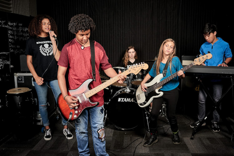 Alunos aprendendo a tocar nos programas da School of Rock para adolescentes