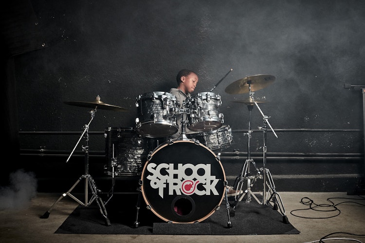 young student playing drums at School of Rock