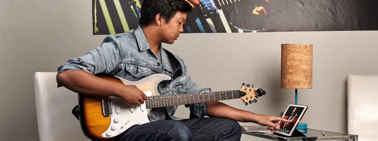 Remote student playing guitar with School of Rock