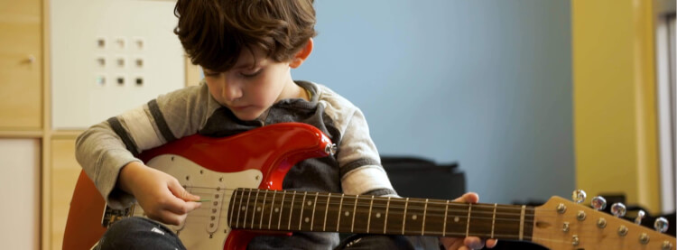 Aluno tocando um instrumento no programa Little Wing, para crianças em idade pré-escolar
