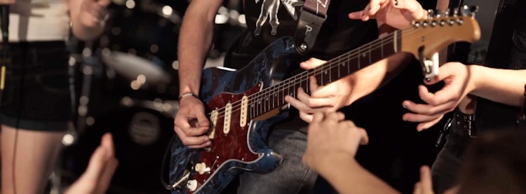 這名青少年正在搖滾教室的「表演課程」中彈奏吉他